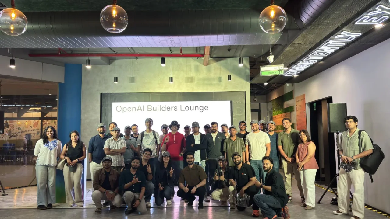 The OpenAI Builders Lounge group photo in Bengaluru, with builders and founders gathered under the event screen